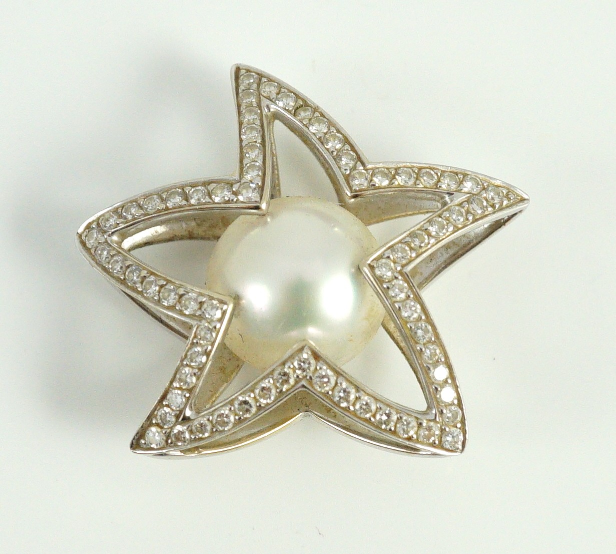 A modern Australian Kailis 18k white gold, single stone South Sea pearl and diamond chip cluster set 'Icon Star' pendant